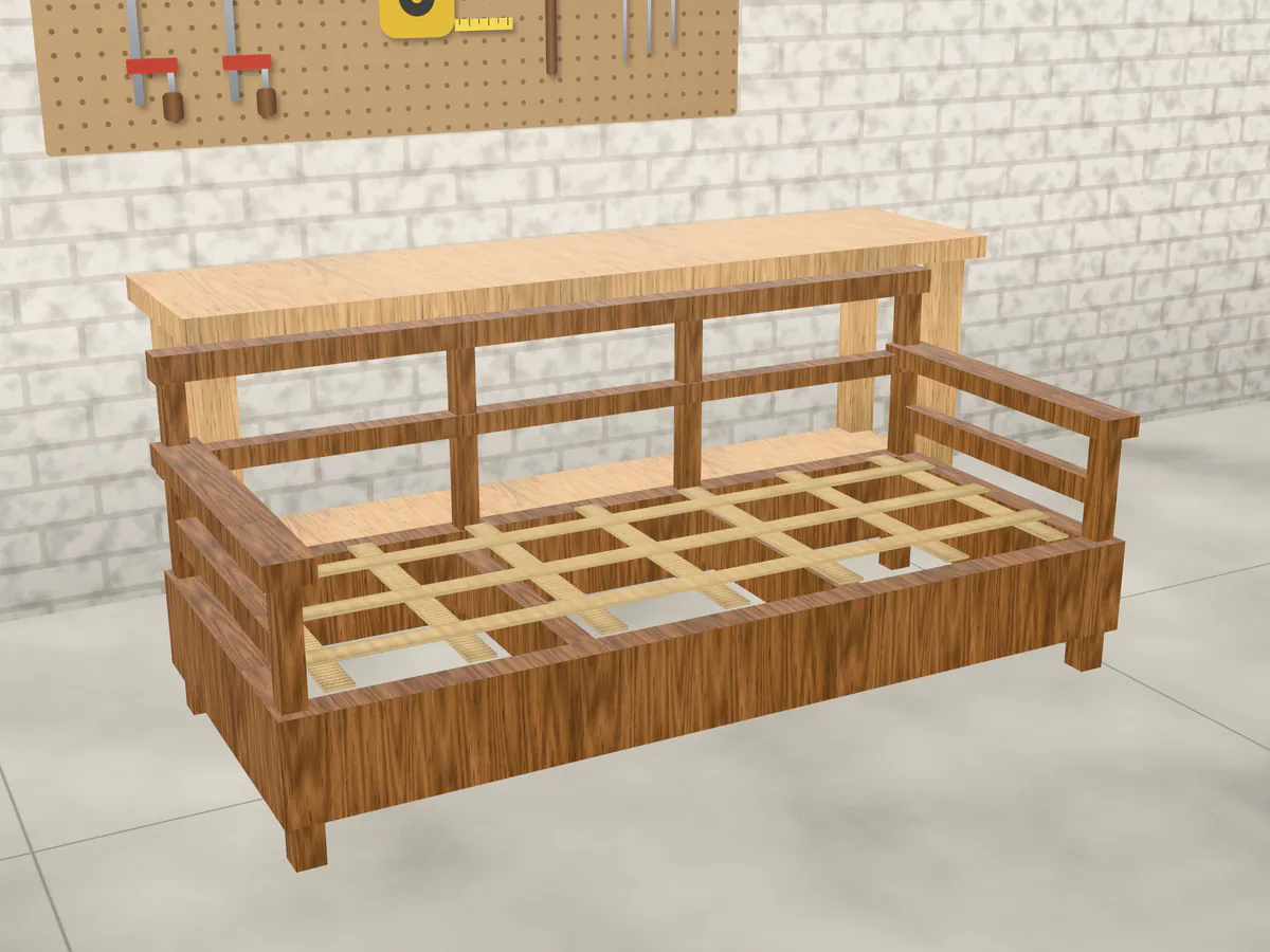 An open wooden sofa frame on the workshop floor